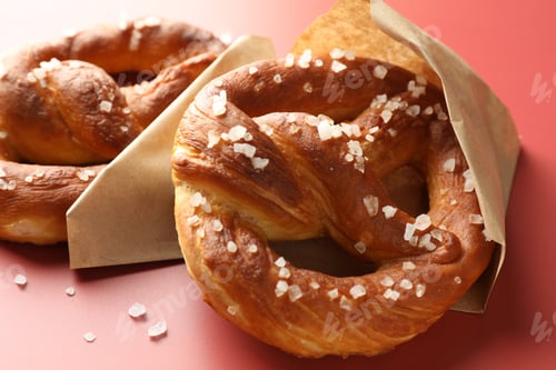 Preview: Tasty pretzels with salt on red background, closeup