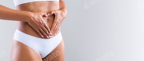Preview: Prignant woman holding heart shaped hands against her small belly
