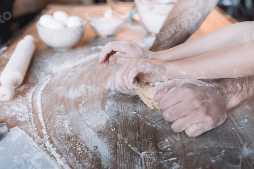 Preview: Close-up partial view of father and daughter kneading dough together