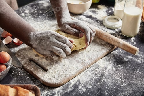 Preview: Top view of talented experienced male cook kneads dough as prepares delicious pastry, works at kitch