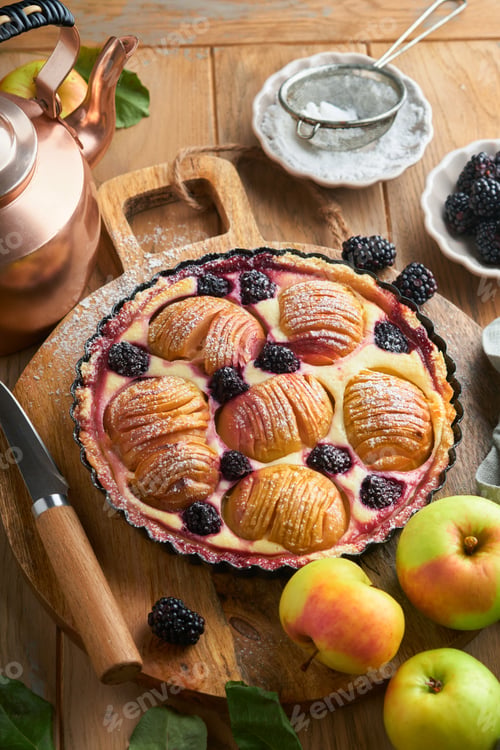 Preview: Apple pie. Apple and blackberries cake or pie decorated sugar powder on old wooden table. Delicious