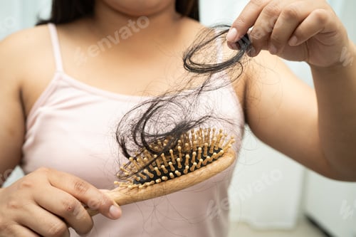 Preview: Asian woman have problem with long hair loss attach to comb brush.