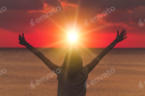 Preview: Woman With Arms Wide Open Looking At The Sunset Over Ocean / Sea.