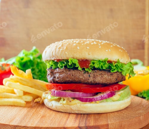 Preview: Delicious hamburger with fresh vegetables and crispy fries served on a wooden board