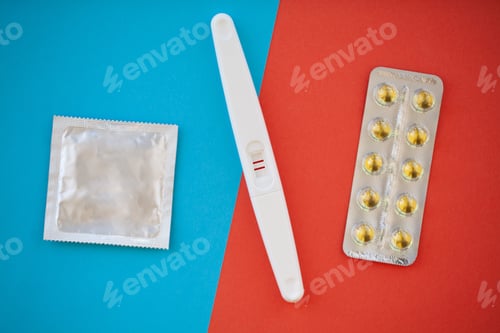 Preview: Close up of pregnancy test and contraceptive pills birth control concept on blue background.