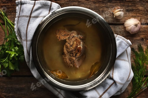 Preview: Meat broth from beef in a metal pan on the wooden table