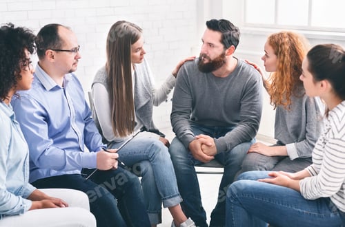 Preview: Therapy Group Members Comforting Upset Man On Community Meeting In Rehab