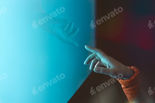 Preview: Connection between humans and cutting-edge technology. A hand touching a screen