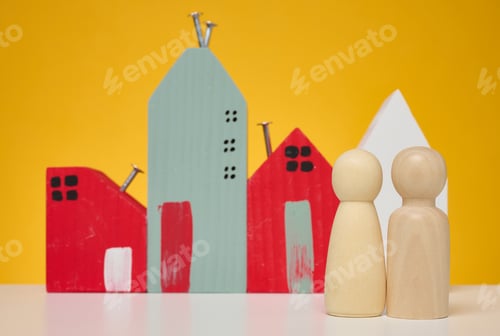 Preview: Wooden house and miniature figurines of a family on a yellow background.