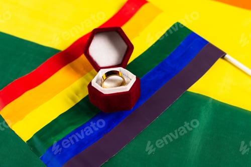 Preview: lgbt flag and wedding ring in jewelry box on rainbow colors background