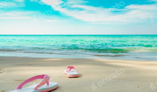Preview: Pink and white sandals on sand beach. Casual style flip-flop were removed. Summer vacation