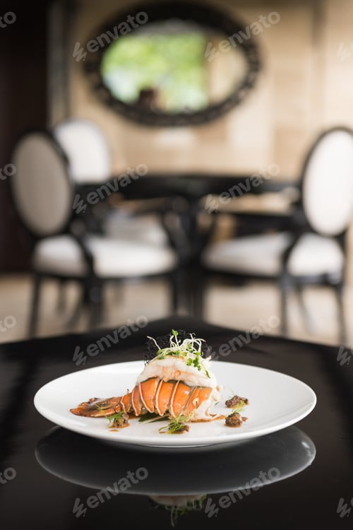Preview: Vertical shot of a dish with shrimp on a white plate with a blurred background