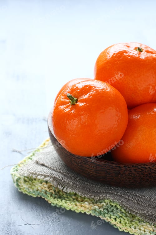 Preview: Bowl of fresh mandarins on green knitted napkin