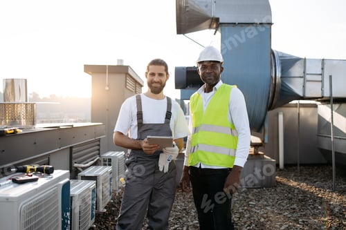 Preview: Craftsmen standing near conditioner and using laptop outdoor