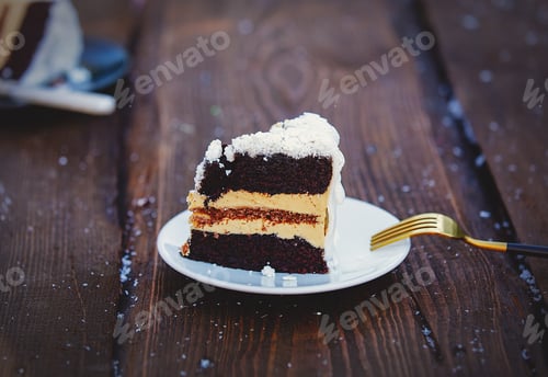 Preview: Christmas cake with fork and snow on wooden table.
