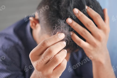 Preview: man hold his list hair close up