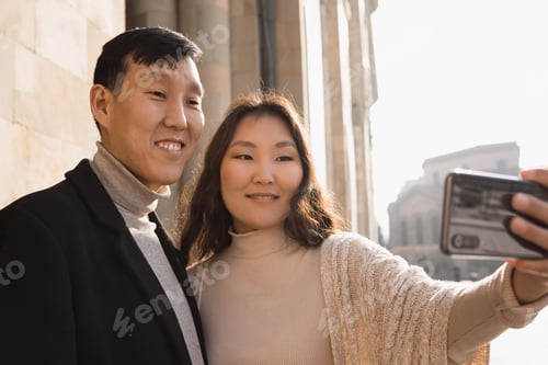 Preview: Happy tourist couple in love travelling in Armenia taking selfie photo in Republic Square of Yerevan