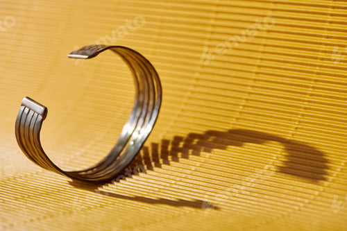Preview: beautiful golden bracelet on yellow striped surface