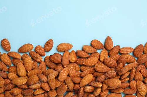 Preview: Tasty almond on blue background, space for text. Vitamin food