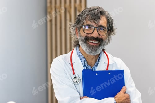 Preview: Smiling senior doctor looking at camera in hospital