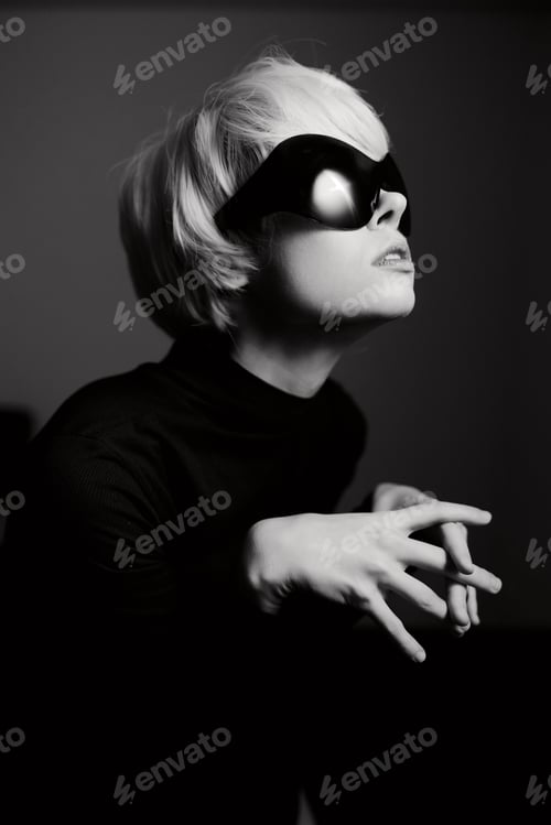 Preview: Stylish woman with short hair wearing sunglasses and a turtleneck, posing dramatically against a