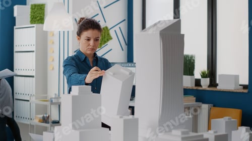 Preview: Portrait of architect looking at building model and maquette to plan urban project