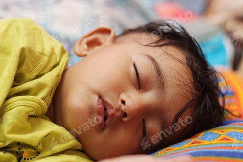 Preview: Cute littlechild sleeping in a colorful bed
