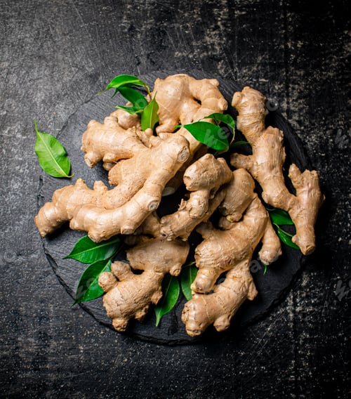 Preview: Fresh ginger with leaves on a stone board.