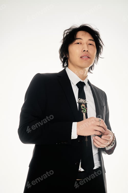 Preview: Young man in stylish suit posing confidently against a minimalist background