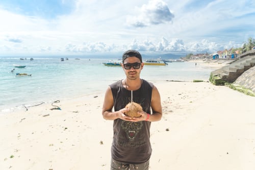 Preview: Guy traveling at beach drinking coconut water