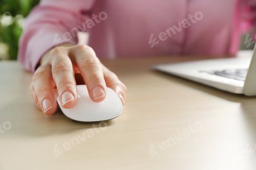 Preview: Woman using computer mouse with laptop at table, closeup