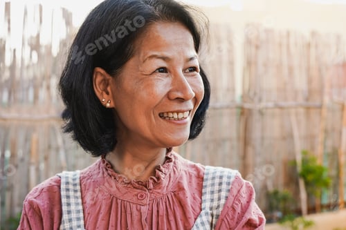 Preview: Happy asian senior woman smiling in front of camera at home terrace