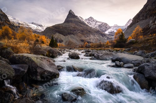 Preview: Valley of Ferpecle in autumn before sunset, with a river surrounded by golden larches