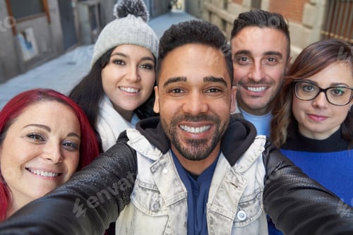 Preview: Smiling diverse friends taking selfie in alley