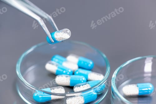 Preview: Scientist Holding Medicine with Pincers Above Petri Dish