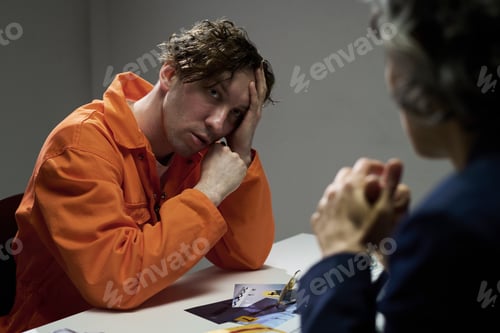 Preview: Pensive Male Inmate in Conversation with Another Person