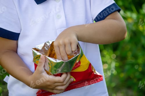 Preview: potato chips in the boy's hand, the boy eats the chips.