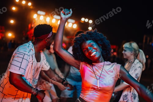 Preview: Young woman dancing and enjoying music festival with friends at night