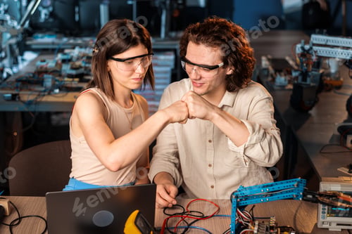 Preview: Young man and woman doing experiments in robotics in a laboratory