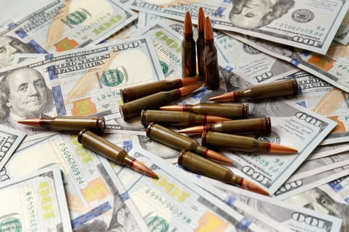 Preview: Bullets lie on American dollar bills, arms trade