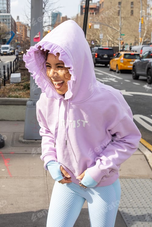 Preview: woman wearing pink hoodie laughing outside