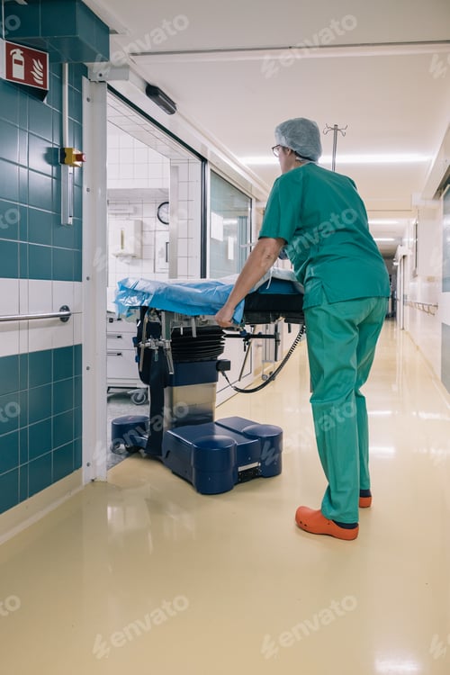 Preview: Medical personnel in green uniforms carry a stretcher into the operating room