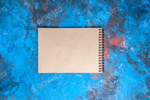 Preview: top view a notebook on blue-red background with copy space