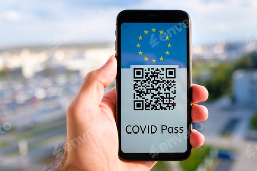Preview: Covid pass with QR code with European Union flag on the screen in smartphone in mans hand on the