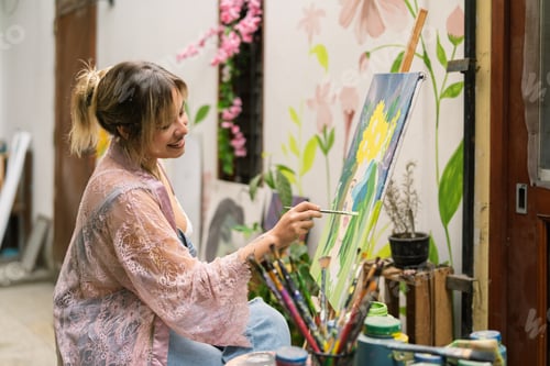 Preview: Female artist painting art on canvas outdoors