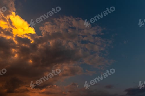 Preview: Perfect background Bright golden orange clouds illuminated by sunlight. Summer evening bright sky