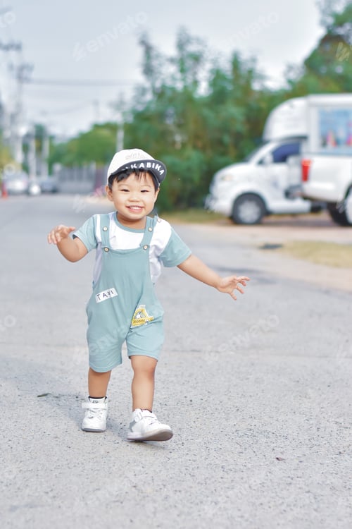 Preview: Portrait of asian cute little boy standing on the street in the morning. Natural sunlight