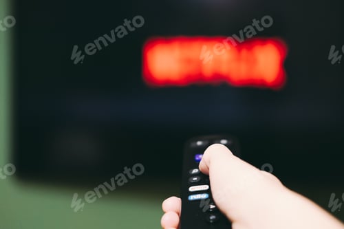 Preview: Woman using remote control to switch streaming service on television