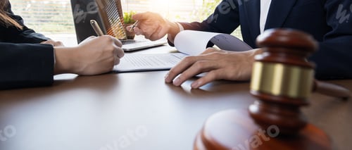Preview: Businessman and lawyer discussing business contract document for legal advice in lawyer's office.