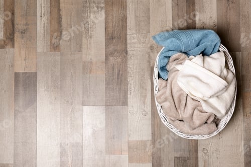 Preview: Laundry basket with dirty clothes on floor, top view. Space for text